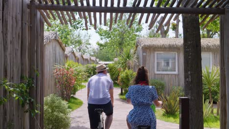 Couple-riding-their-bike-through-the-camping-with-bungalows-in-France