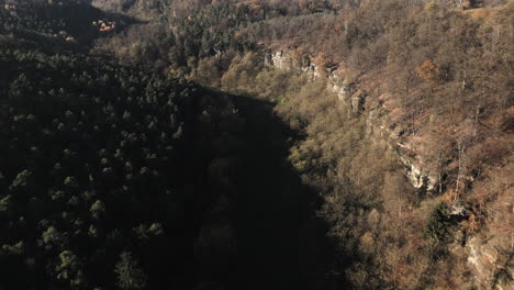 Aerial-view-of-the-valley-and-forests-bordered-by-sandstone-cliffs