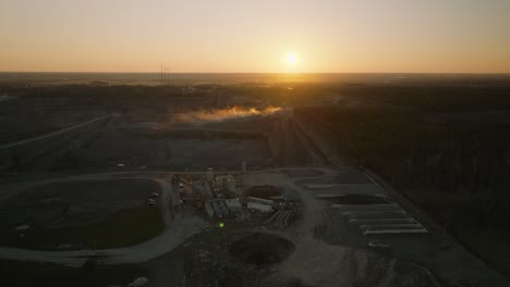 Sunset-over-a-dusty-limestone-quarry-mine-in-a-wooded-landscape