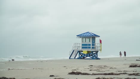 Tropical-Storm,-Lifeguard-house-with-red-flag-on-the-empty-beach-on-a-windy-and-rainy-day