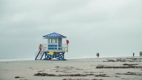 Tropical-Storm,-Lifeguard-house-with-red-flag-on-the-empty-beach-on-a-windy-and-rainy-day