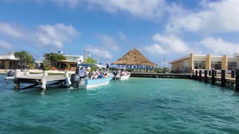 Caribbean-tourist-pier-with-people-inside-motor-boats-ready-to-go-beach,-Los-Roques