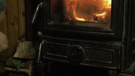 Man-closing-bottom-door-on-wood-burning-stove