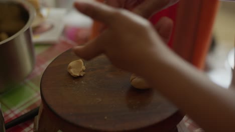 Woman-Hand-Rolling-Dough-into-Roti,-Rotli,-Chapati,-safati,-shabaati,-phulka,-chapo,-roshi,-India,-rolling-pin-into-balls-flat-bread-cultural-food-ethnic-bread