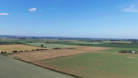 Drone-fly-over-very-flat-farming-fields-in-north-of-England-of-sunny-clear-blue-sky-day