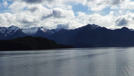 Lake-water-of-Manapuri-and-mountain-ranges-in-New-Zeland,-pan-left-view