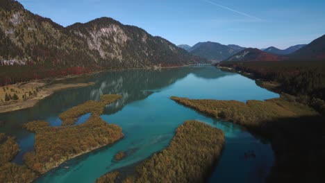 Scenic-Sylvenstein-Speicher-in-autumn,-mountain-valley-river-reservoir-lake-with-fresh-blue-water-in-the-Bavaria-Austria-alps,-flowing-down-a-beautiful-forest-along-trees-near-Walchensee