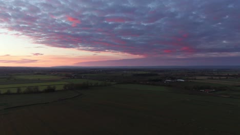 Deep-purple-cloudy-sunset-over-english-countryside-from-aerial-drone-view