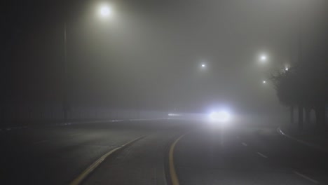 Cars-Traveling-On-A-Misty-Road-At-Night---wide