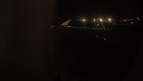 Airplane-wing-seen-from-window-while-landing-at-night