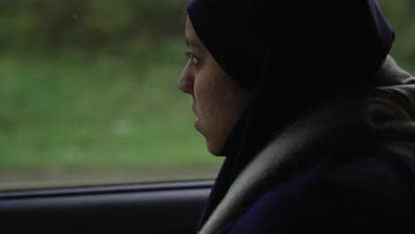 Junge-Muslimische-Frauen,-Die-In-Nachdenklicher-Pose-Aus-Dem-Autofenster-Schauen