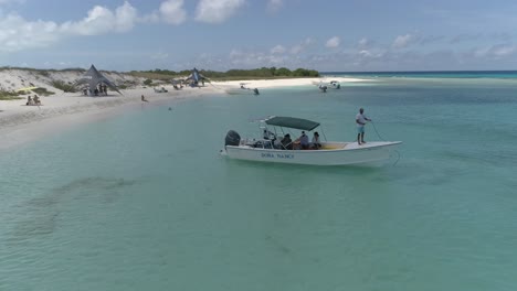 Matrose-Wirft-Anker-Ins-Wasser,-Um-Motorboot-Festzumachen-Und-Touristen-Zum-Karibischen-Strand-Zu-Senken