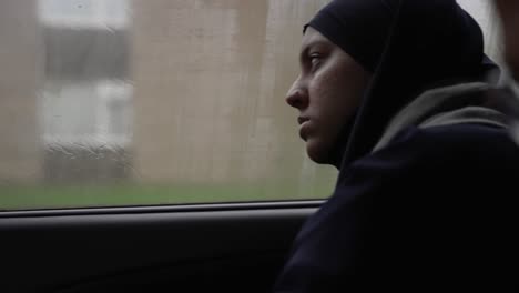 Young-Muslim-Women-Wearing-Hijab-Resting-Head-On-Foggy-Car-Window