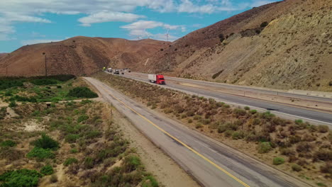 Schwere-Lastwagen-Transportieren-über-Die-Autobahn-In-Der-Heißen-Landschaft-Kaliforniens
