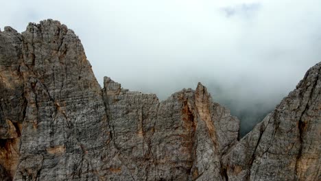 Aerial-views-of-mountain-range-in-the-Dolomites,-Italy,-in-a-foggy-day