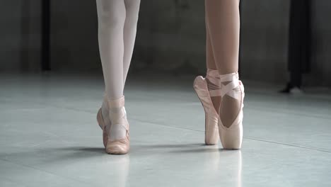 Young-ballerinas-are-balancing-while-standing-on-their-toes,-training-session