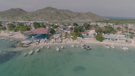 Drone-shot-fishing-village-motorboat,-dock-and-typical-houses,-dolly-out-Gran-Roque