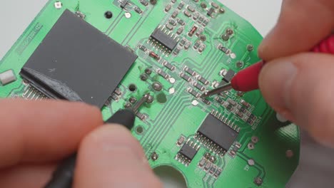 Man-diagnosing-a-faulty-circuit-board-with-a-multimeter