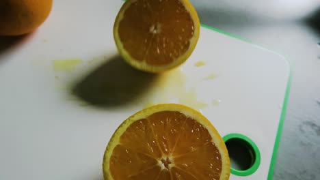 Making-orange-juice:-cutting-the-oranges-on-a-chopping-board-close-up