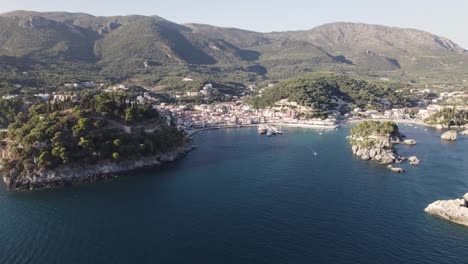 Aerial-arc-shot-over-scenic-bay-on-Ionian-coastline-of-resort-town-Parga,-Greece