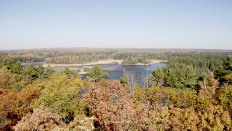 Au-Sable-River-In-Michigan-Während-Der-Herbstfarben-Mit-Drohnenvideo,-Das-Sich-über-Bäume-Vorwärts-Bewegt