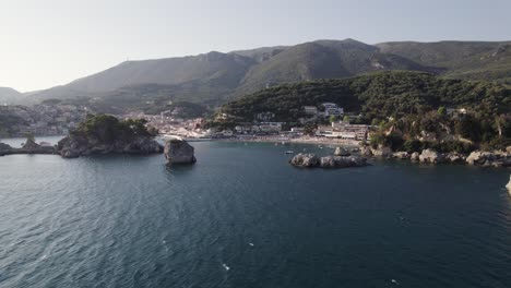 Scenic-Ionian-coastline-of-coastal-town-Parga-in-Greece,-aerial-over-ocean