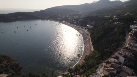 Scenic-aerial-pullback-over-popular-Valtos-beach-and-resort-town-of-Parga,-Epirus---hot-travel-destination-in-Greece