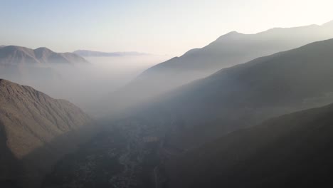 Eine-Drohnenaufnahme-Von-Bergen-Und-Nebel-Während-Des-Sonnenuntergangs,-Die-Fantastische-Lichtstrahlen-In-Peru-Zeigt