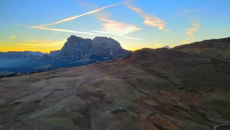 Mountains,-forest-and-grass-fields-with-wooden-cabins-filmed-at-Alpe-di-Siusi-in-Alps,-Italian-Dolomites-filmed-in-vibrant-colors-at-sunrise