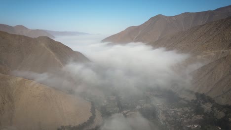 Drohnenaufnahme-Eines-Tals-Voller-Nebel-Und-Blick-Auf-Die-Berge-In-Peru