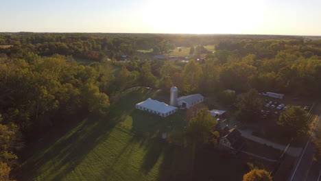 Drone-shot-of-outdoor-wedding-venue-in-a-rural-location-with-fall-colors,-cinematic-aerial-shot