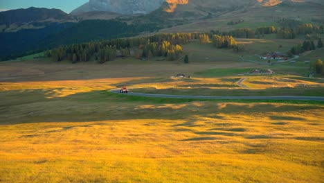 Mountains,-tractor-and-grass-fields-filmed-at-Alpe-di-Siusi-in-Alps,-Italian-Dolomites-filmed-in-vibrant-colors-at-sunset