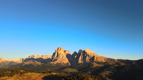 Mountains,-forest-and-grass-fields-with-wooden-cabins-filmed-at-Alpe-di-Siusi-in-Alps,-Italian-Dolomites-filmed-in-vibrant-colors-at-sunset