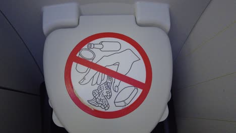 Airplane-bathroom-closed-lid-with-prohibited-sign-zoom-in,-onboard-airplane-interior-4k