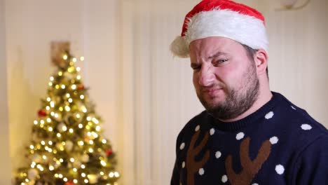 disgusted-man-frowning-while-wearing-Santa-hat