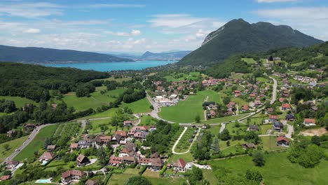 Lake-Annecy-and-Perroix-Mountain-Village-Panorama-in-French-Alps---Aerial