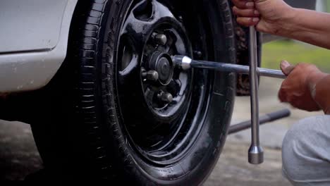 Close-up-shot-of-hand-man-use-wrench-to-fit-the-nut-of-car-rim---Replace-car-wheel-process
