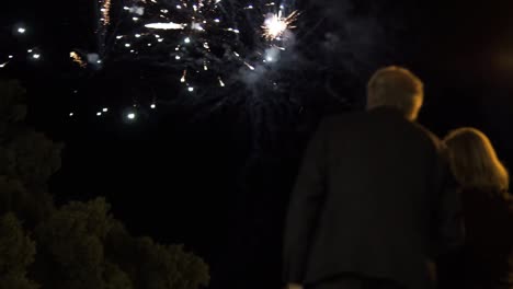 Low-shot-of-an-elderly-couple-standing-next-to-each-other-watching-the-stunning-fireworks