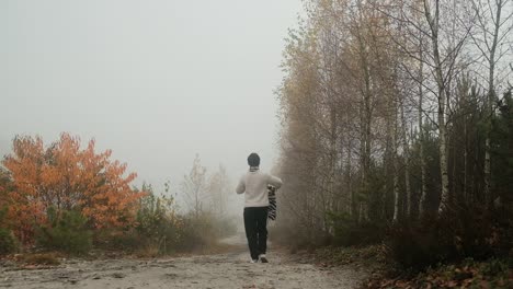 Mujer-Caminando-Por-El-Camino-En-El-Bosque-De-Otoño-En-El-Día-De-Niebla