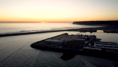 Establishing-drone-shot-over-a-sea-fishing-port-during-sunset