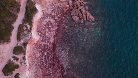 Static-overhead-top-down-aerial-view-of-dreamy-rocky-beach-background,-sunset