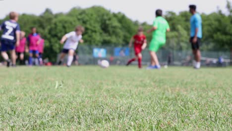 Kinder-Spielen-Fußball-In-Einer-Parklandschaft,-Flacher-Fokus