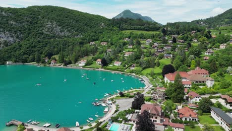 Turquoise-Blue-Lake-Annecy-and-Talloires-Village-in-French-Alps---Aerial