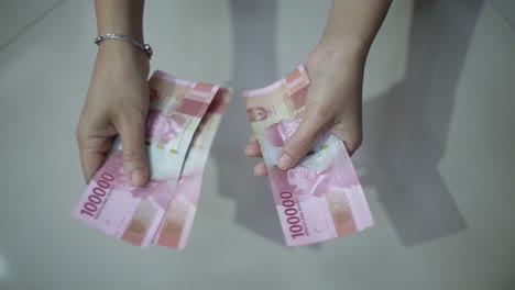 Weibliche-Hände-Zählen-Geld-Rupiah