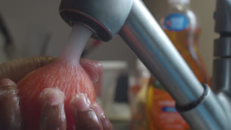Rote-Tomate-In-Küchenspüle-Mit-Hochdruckwasser-Spülen---Nahaufnahme