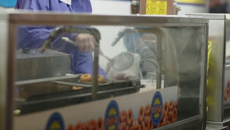 Packing-hot-fresh-mini-donuts-at-a-food-stand-in-a-local-funfair-carnival