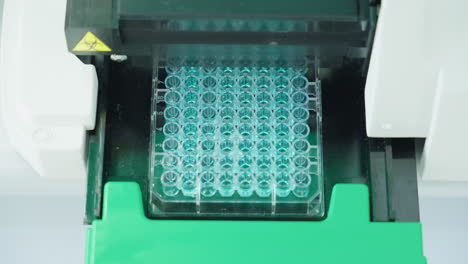 Close-Up-Of-Scientific-Equipment-Machine-Filling-Microplate-In-Laboratory,-4K