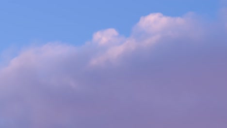 abstract-handheld-closeup-of-clouds-with-purple-hues-in-a-bright-blue-skyline