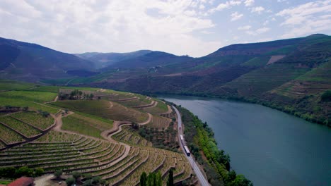 Train-driving-along-Douro-river-and-vineyard-terraces-in-Portugal