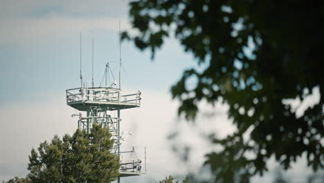Ein-Funkturm-Auf-Trdinov-Vrh,-Den-Man-Durch-Die-Zweige-Des-Baums-Betrachtet